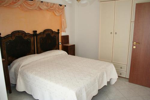 a bedroom with a bed with a white bedspread at Residence Villa degli Ulivi in Bertinoro