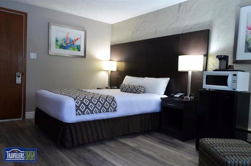 een hotelkamer met een bed en een televisie bij Travellers Inn in Hanover