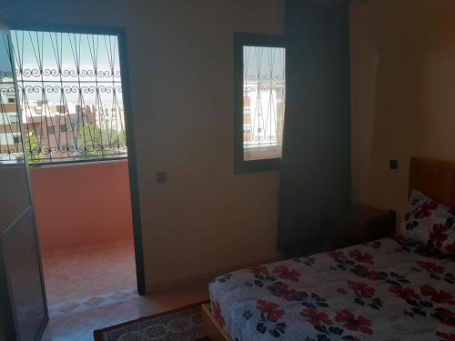 a bedroom with a bed and two windows at Appartement Chham in Marrakesh