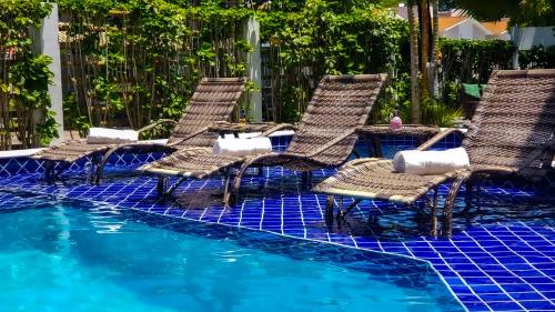 a group of chairs sitting in a swimming pool at Hotel Porto Dourado - Rede Bem Bahia in Porto Seguro
