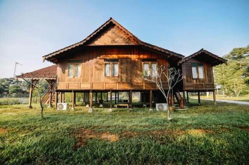 ein großes Holzhaus inmitten eines Feldes in der Unterkunft Perak Agrotourism Resort in Tanjung Tualang