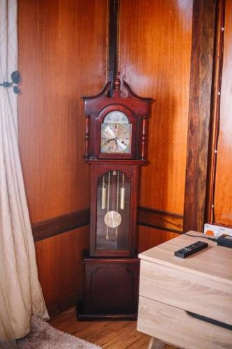 eine Großvater-Uhr in der Ecke eines Zimmers in der Unterkunft Perak Agrotourism Resort in Tanjung Tualang