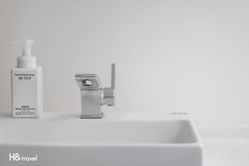 a bathroom counter with a sink and a bottle of soap at Taitung Spring Homestay B&B in Taitung City