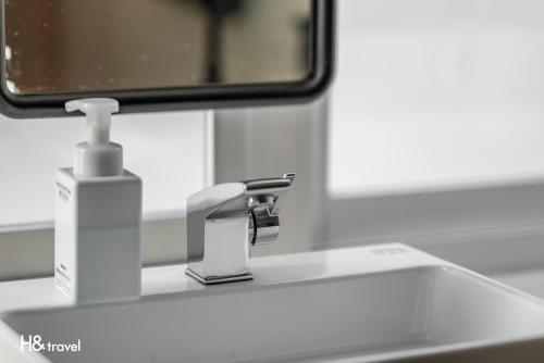 a bathroom sink with a faucet and a mirror at Taitung Spring Homestay B&B in Taitung City