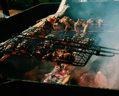 een grill met vlees en ander voedsel erop bij Agua in Sakleshpur