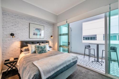 ein Schlafzimmer mit einem Bett und einem großen Fenster in der Unterkunft Princes Wharf Boutique Apartments in Auckland