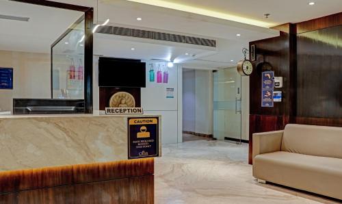 a lobby with a reception desk and a couch at The Onyx Hotel in Jamshedpur