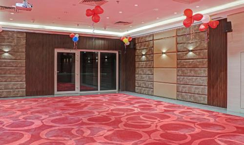 a lobby with a red carpeted floor and red balloons at The Onyx Hotel in Jamshedpur