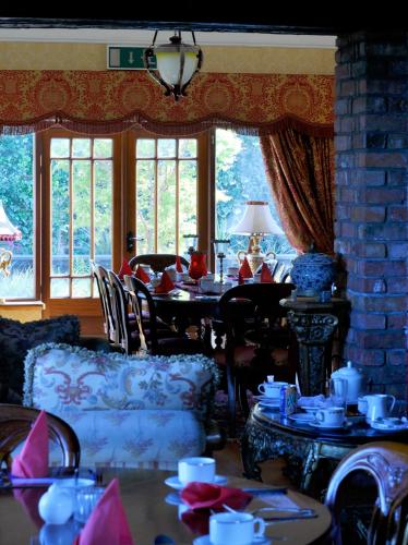 a dining room with tables and chairs and windows at Highfield House Guesthouse in Trim