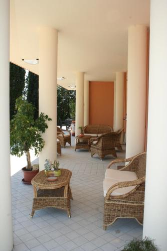 a patio with wicker chairs and tables at Residence Villa degli Ulivi in Bertinoro