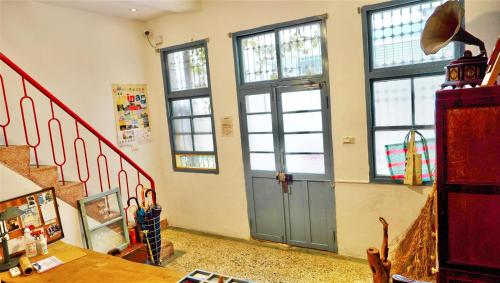 a room with a blue door and some windows at Chung Fu Inn in Tainan