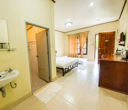 ein Badezimmer mit einem Schlafzimmer mit einem Bett und einem Waschbecken in der Unterkunft ศศิธารา การ์เด้นท์ in Sichon