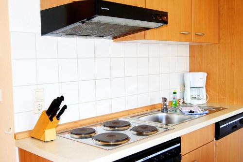 a kitchen with a stove and a sink at Ferienwohnung im Haus Katharina in Lauterbach