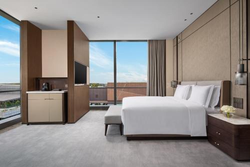 a bedroom with a large white bed and a large window at Crowne Plaza Shanghai Hongqiao by IHG in Shanghai