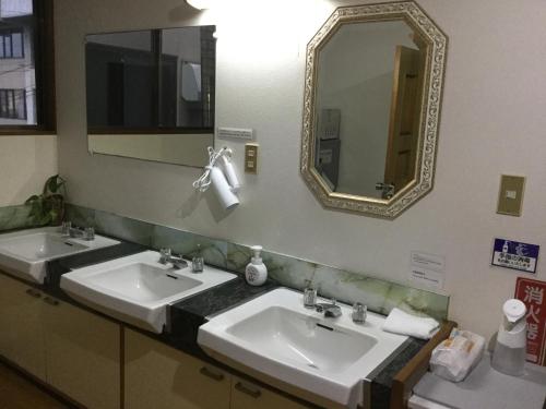 a bathroom with two sinks and a mirror at Tobei in Nozawa Onsen