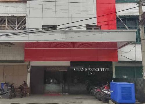 a store front with a red and white building at RedDoorz Plus @ Jalan Letda Sujono Medan 2 in Pulauberayan Dadap