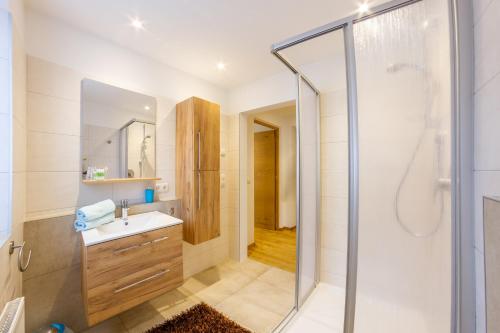 サン・レオナルド・イン・パッシーリアにあるApartments Hubertus - central St Leonhard - free parking - Netflix - PasseiertalCard included - hiking and biking from doorstepの洗面台とシャワー付きのバスルーム