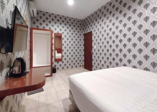 a bedroom with a bed and a wall at RedDoorz Plus @ Jalan Letda Sujono Medan 2 in Pulauberayan Dadap