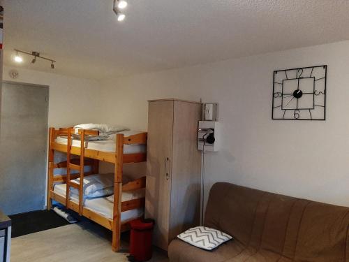 un soggiorno con letto a castello e divano di Studio rénové, calme avec Terrasse S-O, prestations de qualité - Résidence Les Adraits a Les Rousses