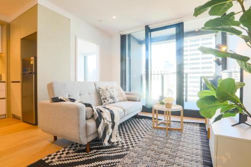 a living room with a chair and a table at KOZYGURU DOCKLANDS MODERN COZY 1 BED ROOM UNIT MELBOURNE VDO628 in Melbourne