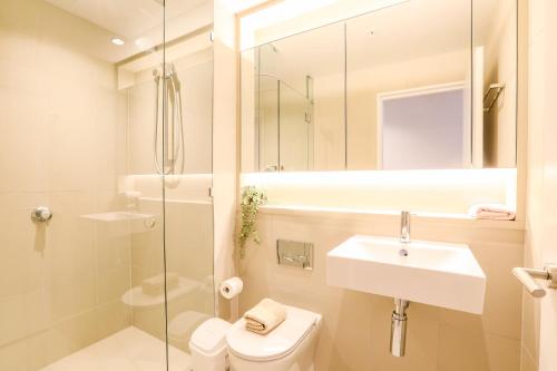 a bathroom with a sink and a toilet and a shower at KOZYGURU DOCKLANDS MODERN COZY 1 BED ROOM UNIT MELBOURNE VDO628 in Melbourne