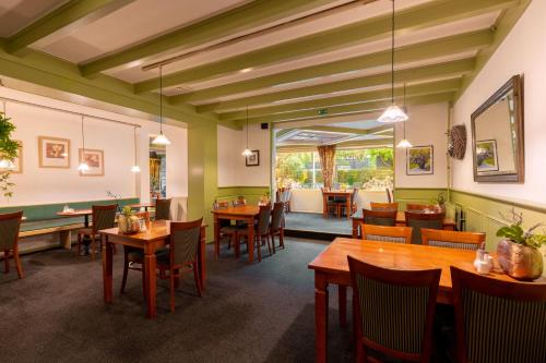 a dining room with wooden tables and chairs at Owl Hotel in Amsterdam
