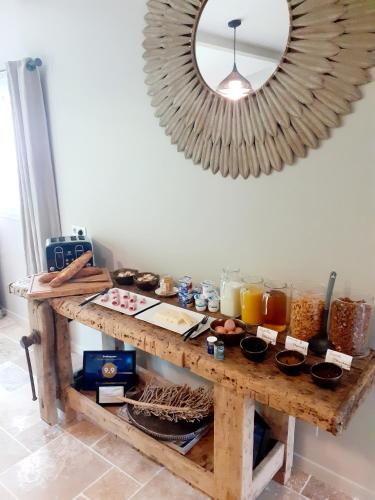 a table with food and a mirror on the wall at Domaine de la Limetiere in Neuvy-le-Roi