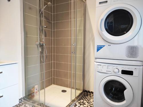 une cabine de douche avec un lave-linge et un lave-linge dans l'établissement Maison avec jardin en centre ville - proche gare et circuit 24h du mans, au Mans