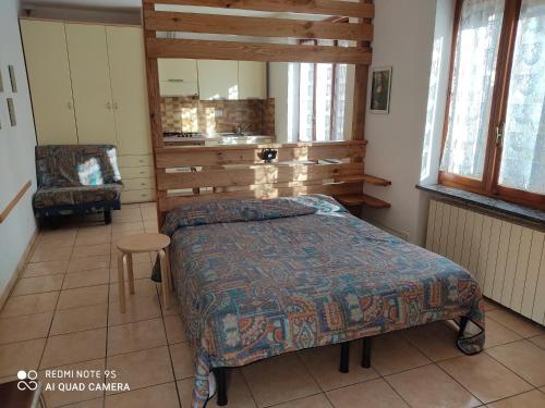 a bedroom with a bed and a chair at Residenza La Ruina in Fenestrelle