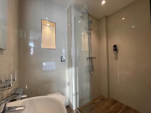 a bathroom with a shower and a sink at H3 Hotel Rotterdam City Center in Rotterdam