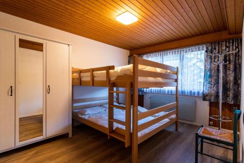 Zimmer mit Etagenbett, 2 Etagenbetten und einem Fenster in der Unterkunft Fyfauter 1 in Schwarzsee