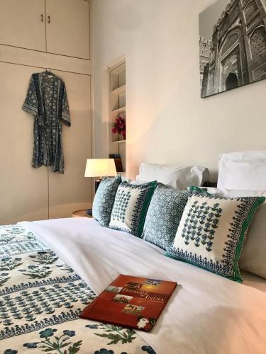 a bed with pillows and a coat hanging on the wall at Mizpah Delhi in New Delhi