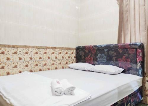 ein Bett mit zwei Handtüchern darüber in der Unterkunft Queen Asri Mitra RedDoorz in Kediri