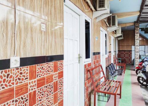un pasillo de un edificio con bancos y motocicletas en Queen Asri Mitra RedDoorz, en Kediri