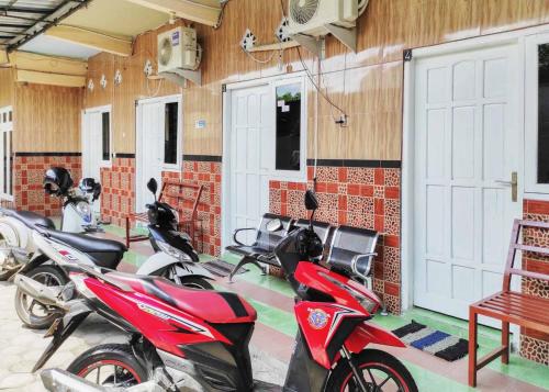 een groep motorfietsen geparkeerd in een garage bij Queen Asri Mitra RedDoorz in Kediri