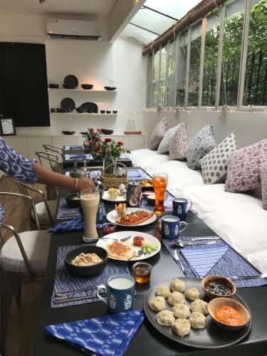a table with many plates of food on it at Mizpah Delhi in New Delhi