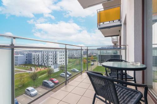 a balcony with a table and chairs and a view of a city at Apartment Gdańsk Jabłoniowa by Renters in Gdańsk