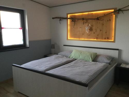 1 dormitorio con 1 cama con luz en la pared en Ferienwohnungen "Blumenwiese", en Dilinga