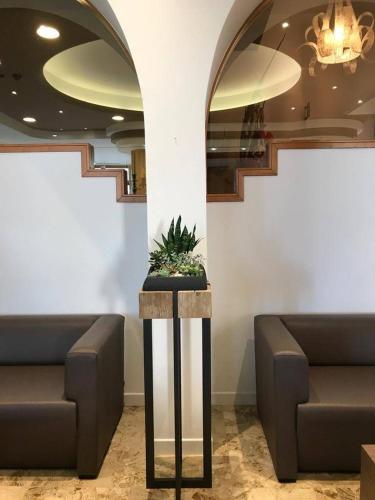 a lobby with two couches and a table with a plant at Hotel Italy in Bibione