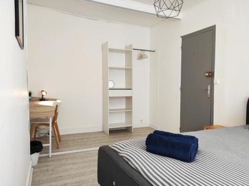 une chambre avec un lit avec un oreiller bleu dessus dans l'établissement Maison avec jardin en centre ville - proche gare et circuit 24h du mans, au Mans