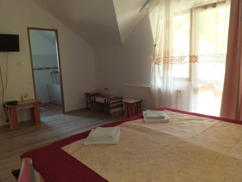 a bedroom with a bed with two towels on it at Pensiunea Gură de Rai, Pojorâta in Pojorîta