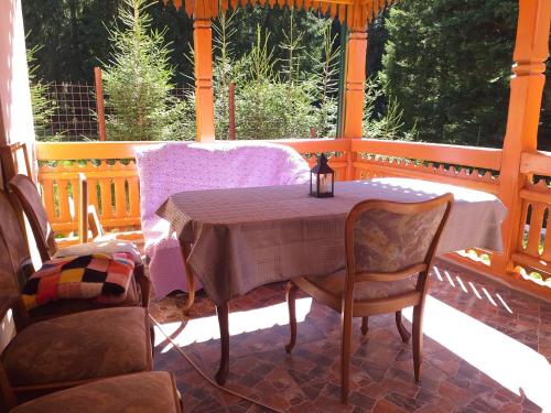 porche con mesa y sillas en Pensiunea Gură de Rai, Pojorâta, en Pojorîta