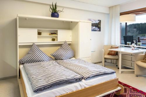 - une chambre avec un grand lit et un bureau dans l'établissement Ferienwohnung Nina, à Schönwald