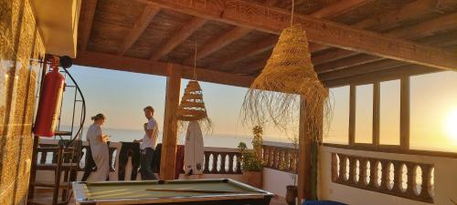 a group of people standing on a deck with a pool table at GOLVEN Surf in Taghazout