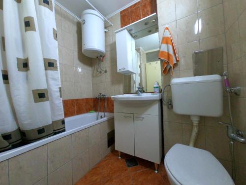 La salle de bains est pourvue de toilettes, d'un lavabo et d'une baignoire. dans l'établissement Apartman UNA Travnik, à Travnik