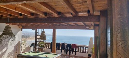 a balcony with a pool table and a view of the ocean at GOLVEN Surf in Taghazout