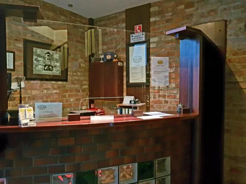 a cashier counter in a brick wall at Amadeus Hotel Zielona Góra in Zielona Góra