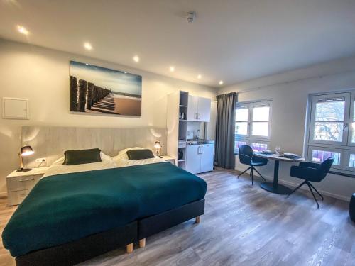 a bedroom with a large green bed and a desk at Appartement Centrum Domburg DO05 in Domburg