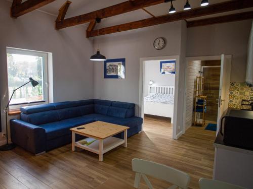 a living room with a blue couch and a table at Apartamenty Park in Ciechocinek