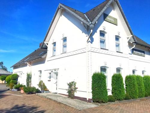 a white building with a black roof at Hotel Hemdinger Hof 